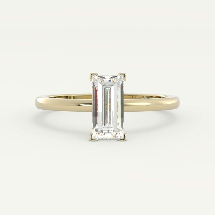 an emerald - cut diamond ring in yellow gold, set with a thin band on the side