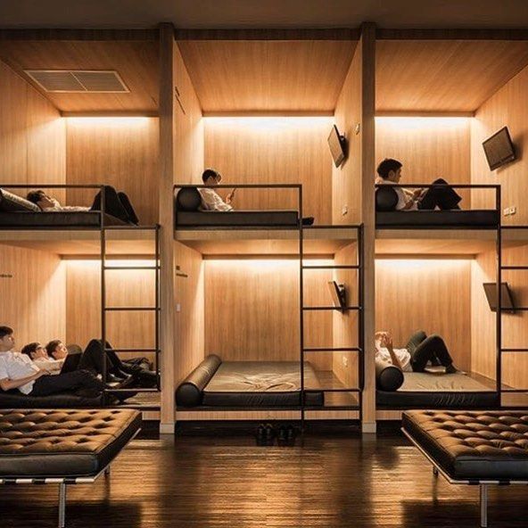 bunk beds with people sitting on them in a room that has wood paneled walls