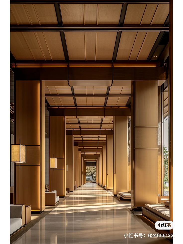 an empty hallway with lots of windows and wooden paneling on the walls, leading to another room