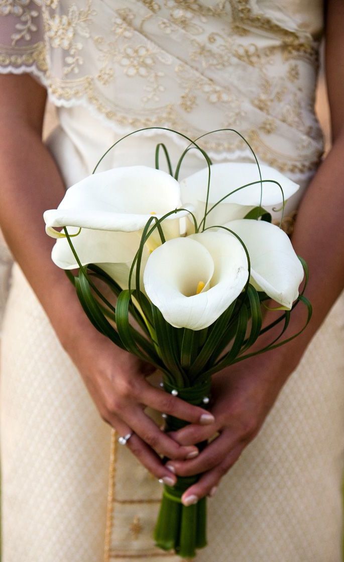 a woman holding a bouquet of white flowers