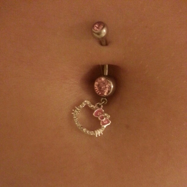 a woman's belly with two charms attached to it