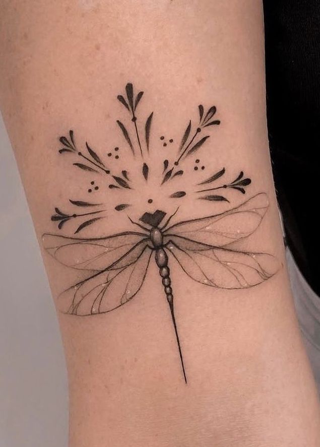 a black and white photo of a dragonfly tattoo