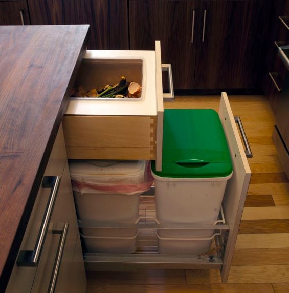 a kitchen with a sink, dishwasher and trash can in it's drawer