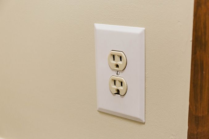 an electrical outlet with two light switches on the wall