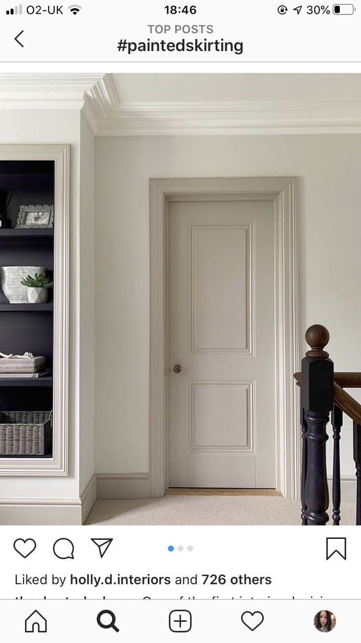 an empty room with a white door and some bookshelves