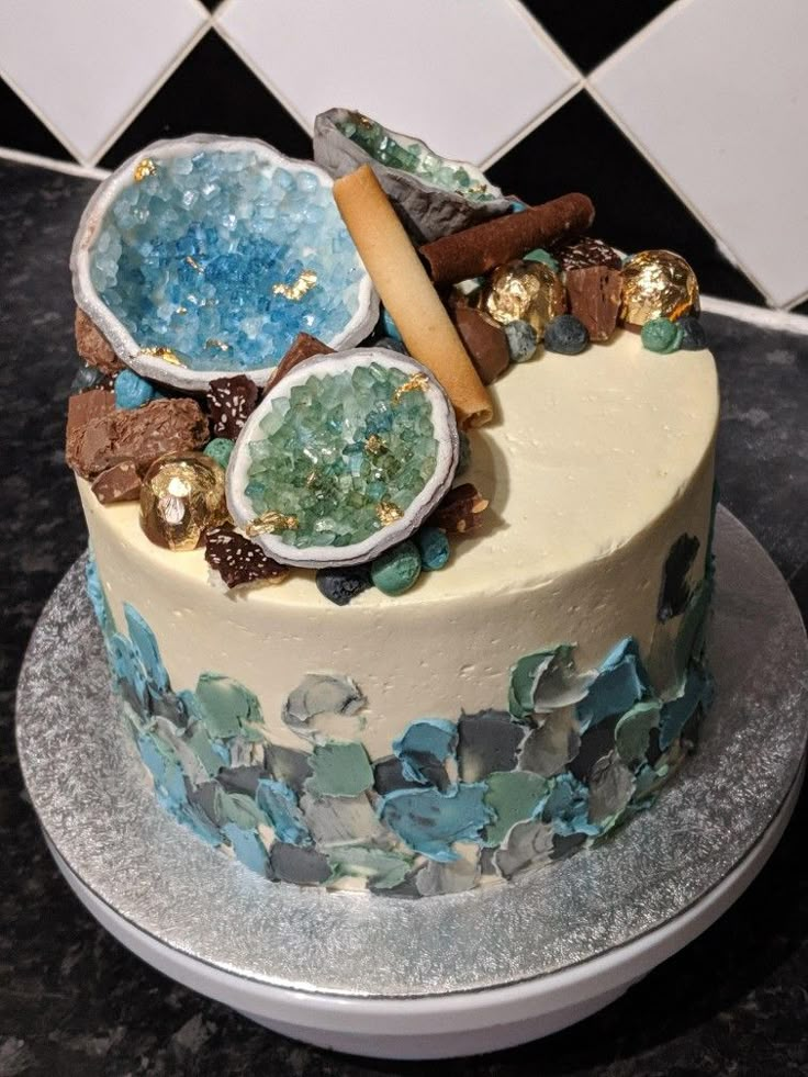 there is a cake with blue and white frosting on the top that has various things in it