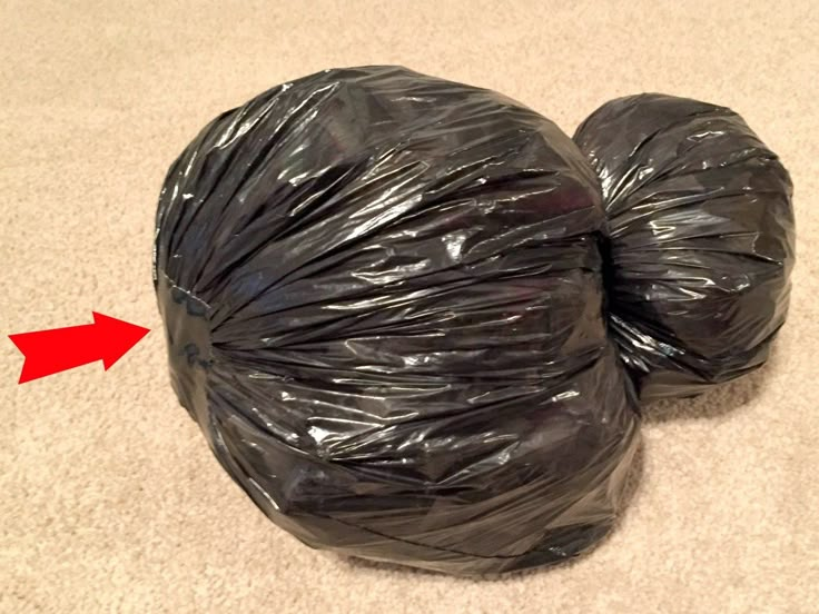 two black bags are sitting on the floor next to each other with an arrow pointing towards them