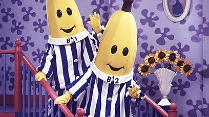 two bananas dressed in jail clothes standing next to each other with their arms around each other