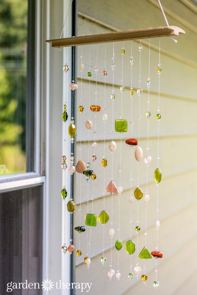 a wind chime hanging from the side of a house in front of a window