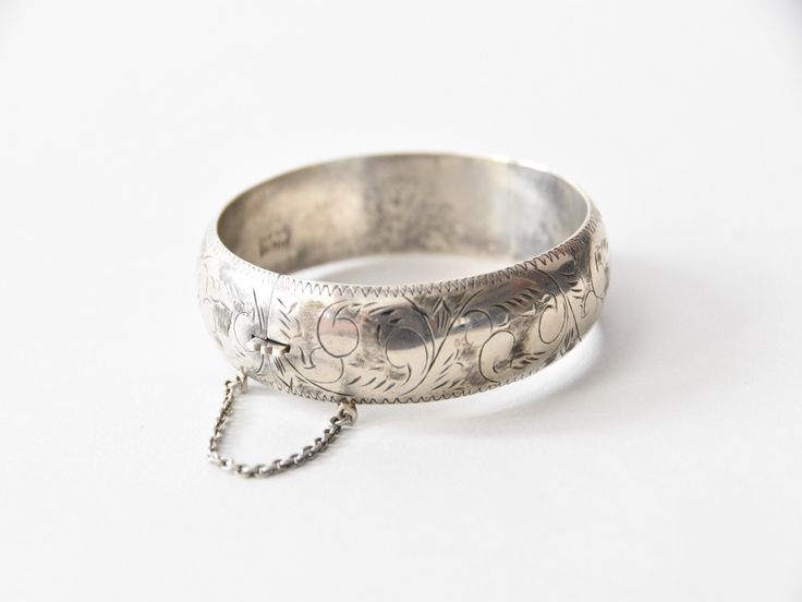 "Antique victorian sterling silver bangle. Etched scroll design all around. Markings inside (hard to make out). Push release clasp and a safety chain. Light patina but can be polished if desired. A great addition to any bracelet stack. Condition | good, two small indentations, refer to photos. request further photos if needed. Measurements ✂--- Best fit | inner circumference 2 1/2\" Markings | present but hard to make out ★★Visit The Shop★★ http://www.etsy.com/shop/seaofvintage ➸ Find the shop o Victorian Style Engraved Silver Bangle, Victorian Style Silver Engraved Bangle, Victorian Silver Engraved Bangle, Victorian Sterling Silver Engraved Wedding Bracelet, Engraved Antique Silver Cuff Bracelet For Weddings, Ornate Engraved Wedding Bangle, Ornate Engraved Bangle For Wedding, Engraved Sterling Silver Bracelet For Wedding, Etched Sterling Silver Bangle Bracelet For Wedding