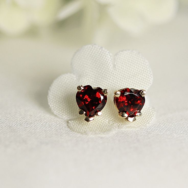 "These minimalist and modern heart garnet stud earrings are a beautiful choice for anyone who loves elegant and understated jewelry. The 14k gold prong setting provides a secure and luxurious setting for the red gemstone, while the heart shape adds a touch of sweetness to the design. As a birthstone for January, garnet is said to represent love, loyalty, and friendship, making these earrings a thoughtful gift for anyone born in that month. SOLD AS PAIR. Available white gold or yellow gold from d Elegant Heart Shaped Earrings For Anniversary, Elegant Heart-shaped Earrings For Anniversary, Elegant Heart-shaped Gemstone Earrings, Elegant Heart Birthstone Earrings As Gift, Heart Cut Gemstone Earrings For Wedding, Elegant Heart Birthstone Earrings For Gift, Elegant Heart Earrings With Birthstone For Gift, Wedding Heart Cut Gemstone Earrings, Elegant Sterling Silver Heart Birthstone Earrings