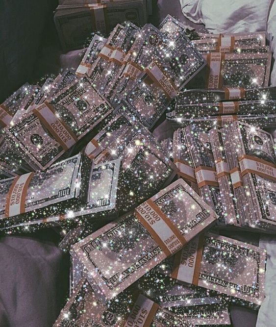 a pile of money sitting on top of a bed covered in stars and sparkles