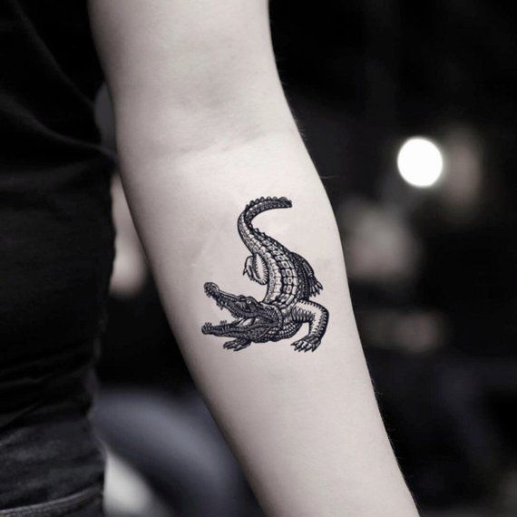 a woman's arm with a black and white tattoo design on the left forearm