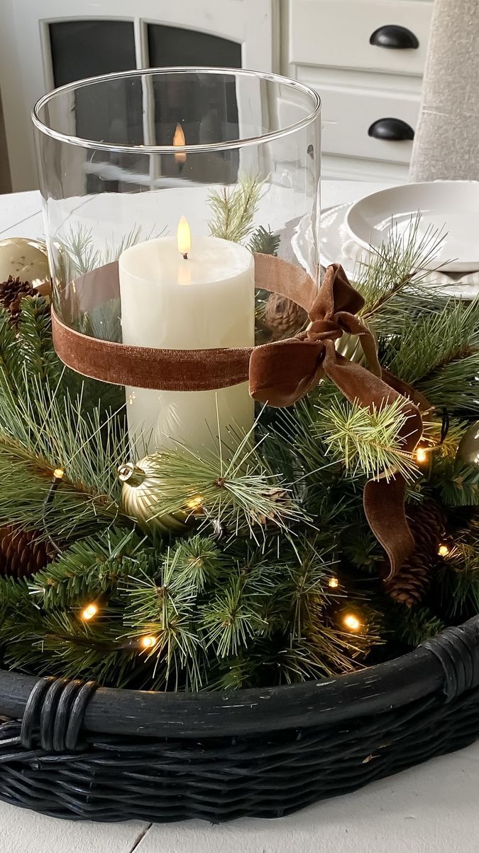 a christmas centerpiece with pine cones and candles