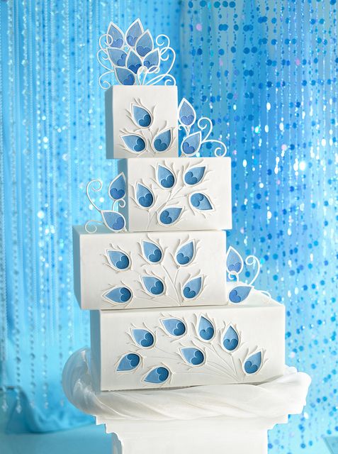 a three tiered cake with blue flowers on it