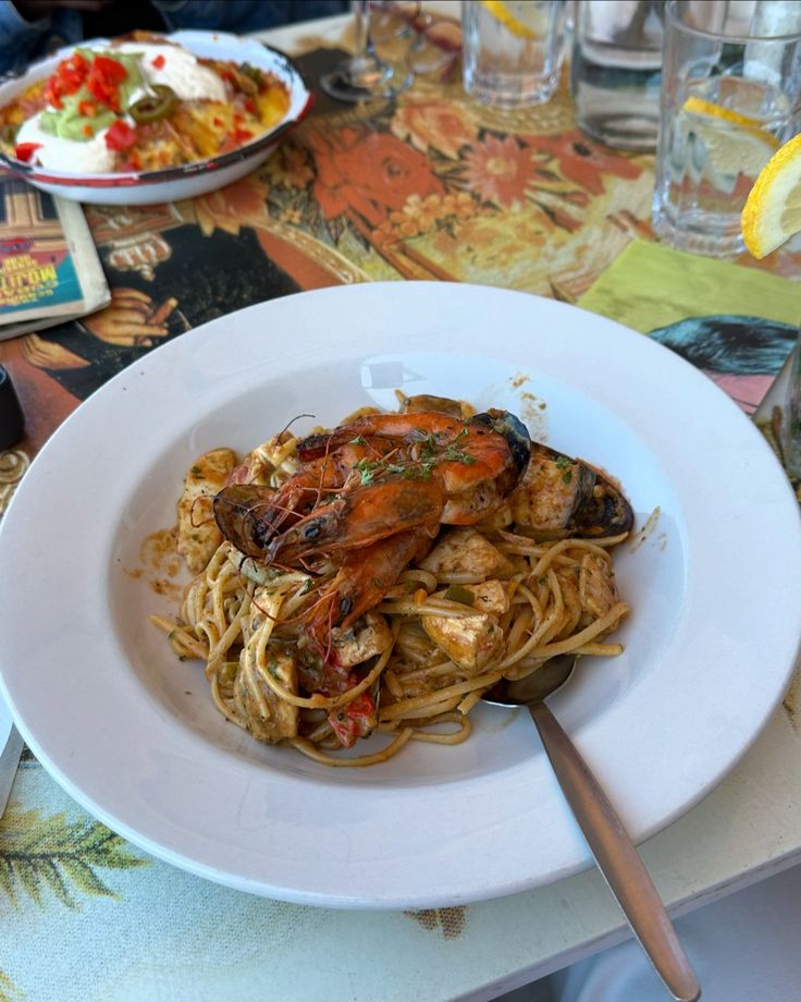 a white plate topped with pasta and shrimp