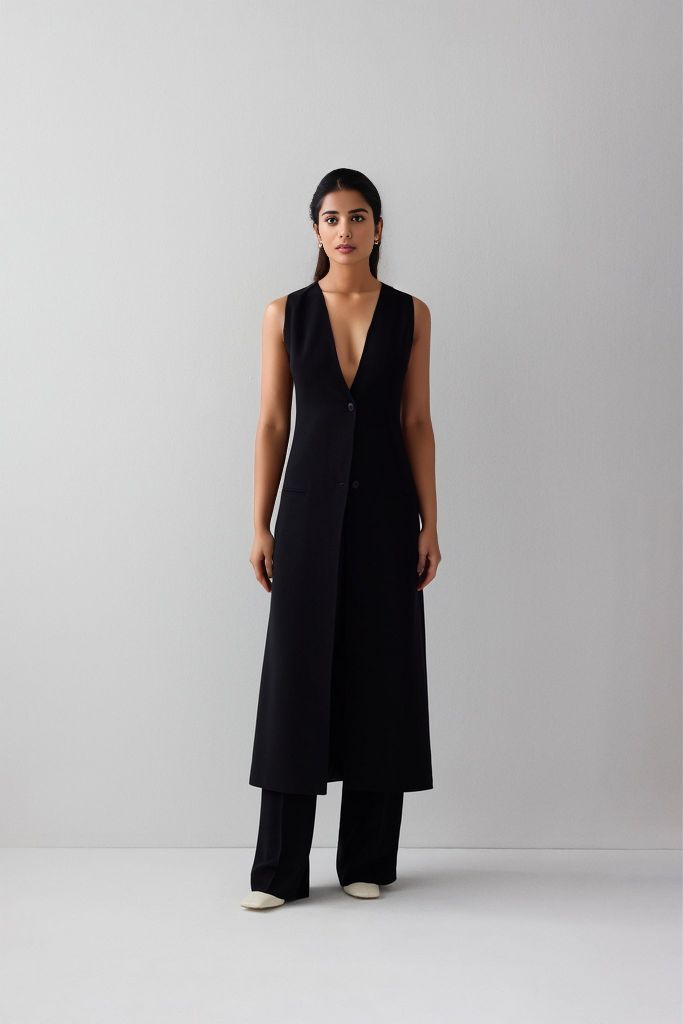 A touch of sophistication to your wardrobe with our idée long vest. Made from high-quality puerto rico fabric and lined for ultimate comfort, this contemporary vest features two buttons, two side pockets, and a single back vent. The versatile design and casual aesthetic make it perfect for everyday wear, while the sleek fit and formal aesthetic make it suitable for any formal occasion. You can even wear it outdoors for an added touch of style. The blend of polyester and viscose ensures you stay Sleeveless Vest With Hidden Buttons For Office, Business Vest With Hidden Button Closure, Sleeveless Business Vest Outerwear, Sleeveless Business Vest With Hidden Button Closure, Chic Tailored Vest Outerwear, Chic Sleeveless Vest With Hidden Button Closure, Business Vest With Single Button Sleeveless, Business Vest With Single Button, Classic Single-breasted Sleeveless Vest