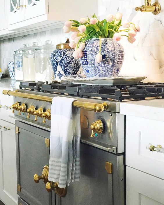 a potted plant sitting on top of an oven next to a towel hanging from the handle