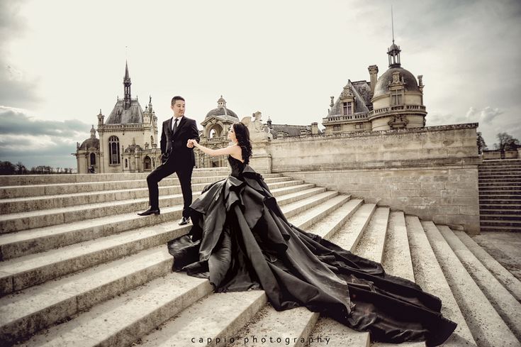 a man in a tuxedo standing next to a woman in a black dress