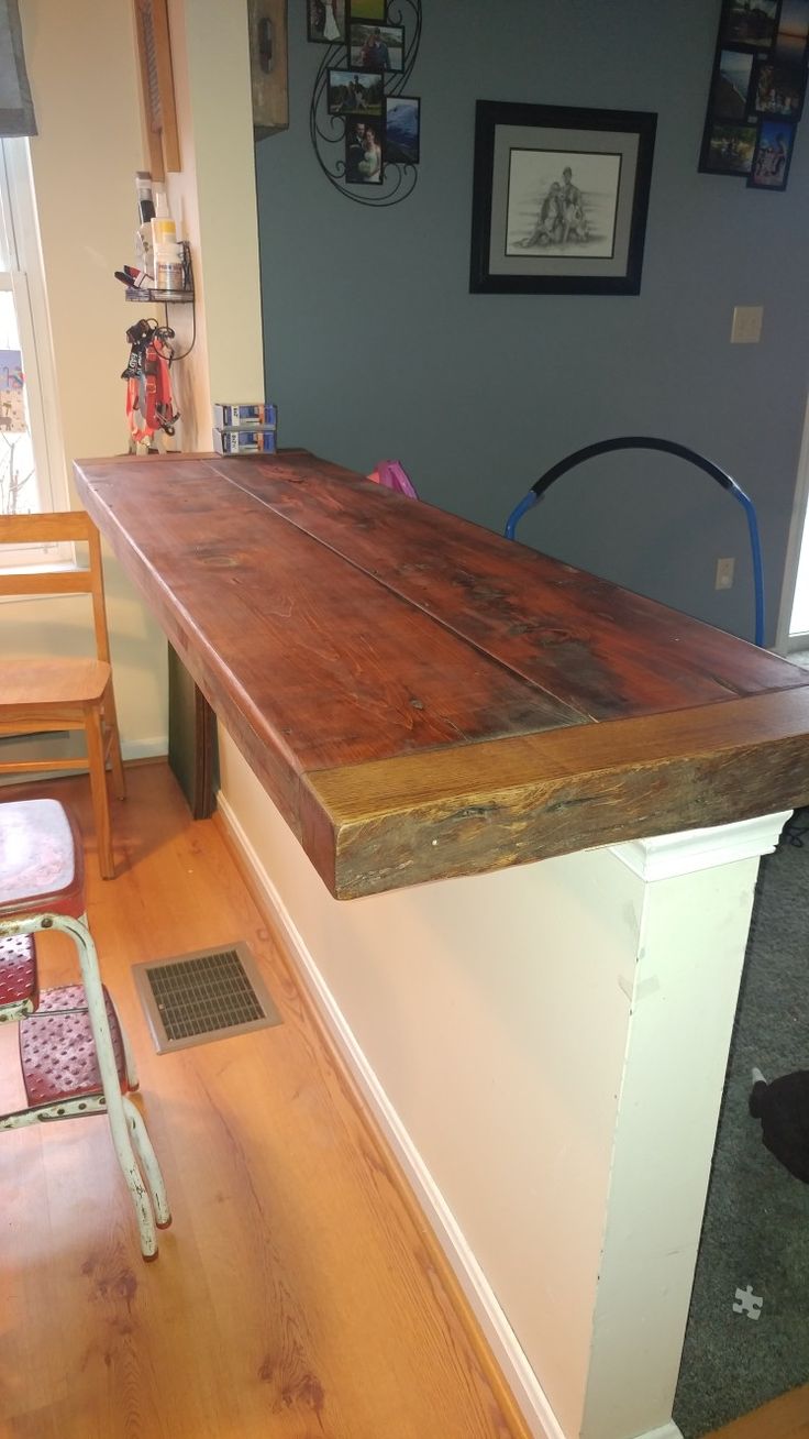 a wooden counter top sitting on top of a hard wood floor next to a chair