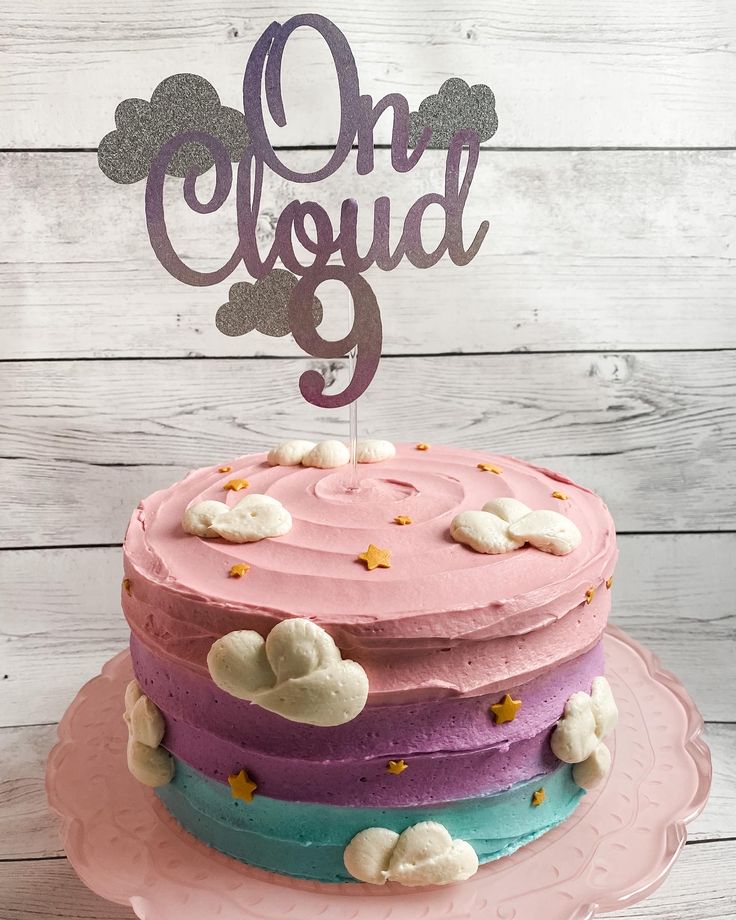 a cake that is sitting on top of a pink and blue plate with the words cloud 9