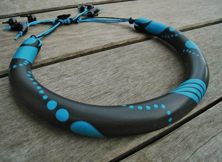 a blue and black necklace sitting on top of a wooden table