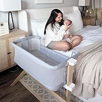 a woman sitting on top of a bed next to a baby in a crib