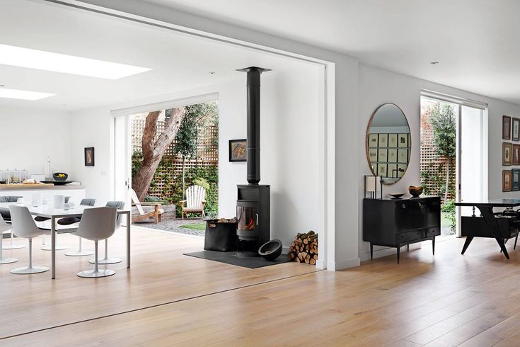 a living room filled with furniture and a fire place in the middle of a wooden floor