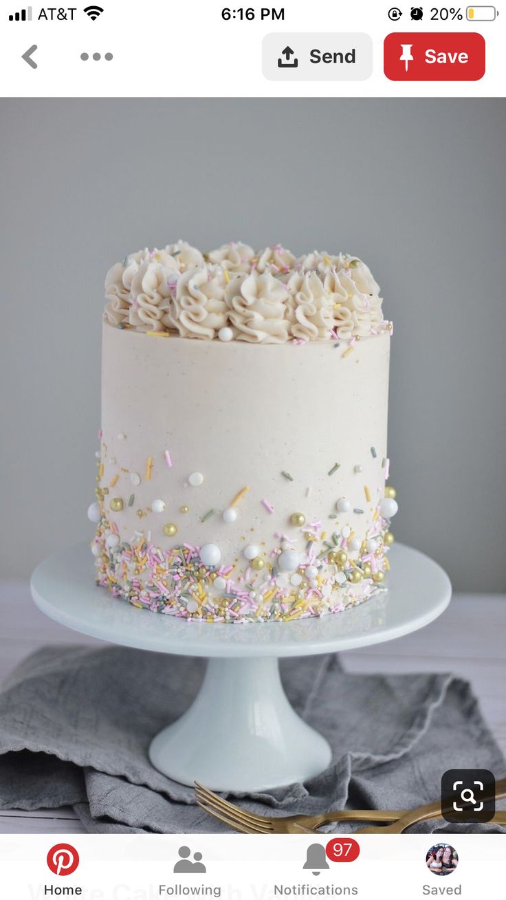 a white cake topped with sprinkles and frosting on top of a table