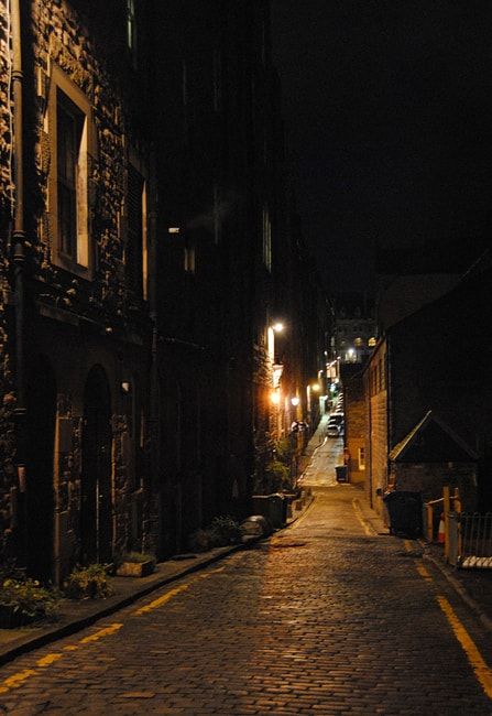 an empty street at night with no one on the sidewalks or people walking down it