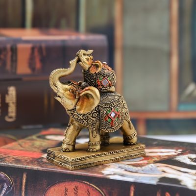 an elephant figurine sitting on top of a table next to some book cases