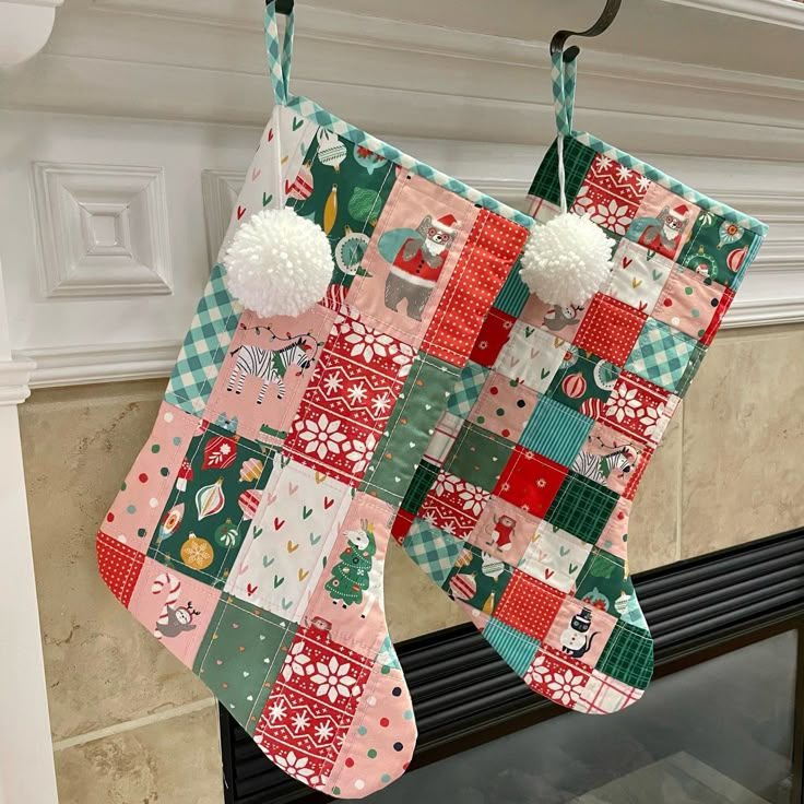 two christmas stockings hanging from a fireplace mantel decorated with patchwork and pom - poms