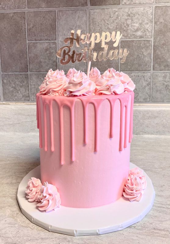 a birthday cake with pink frosting and flowers