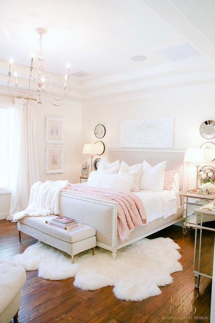 an instagram page with a white bed and chandelier in the middle, on top of a wooden floor