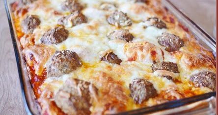 a casserole dish with meatballs and cheese