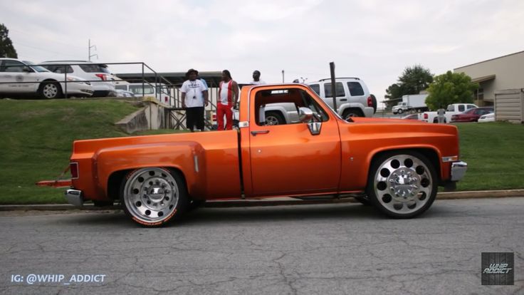 an orange pick up truck parked on the street