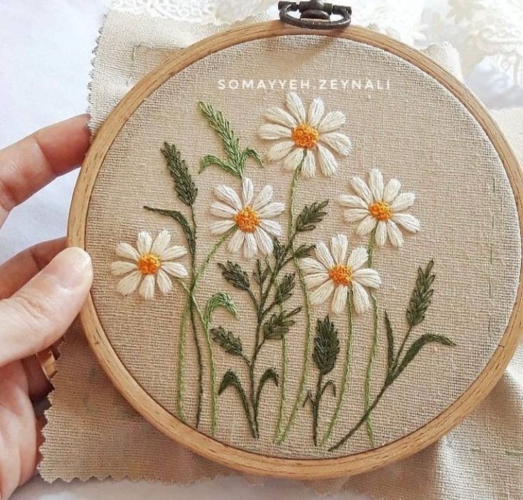 someone is stitching some daisies on a piece of fabric with the words, something personal