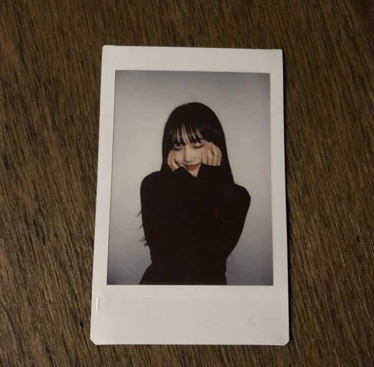 a polaroid photo of a woman covering her face