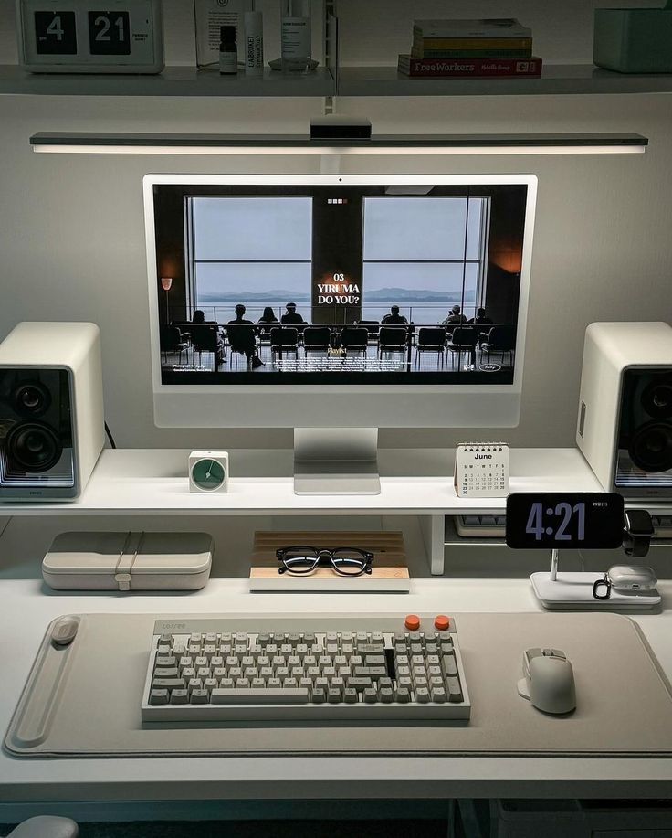 there is a computer on the desk with speakers and a keyboard in front of it