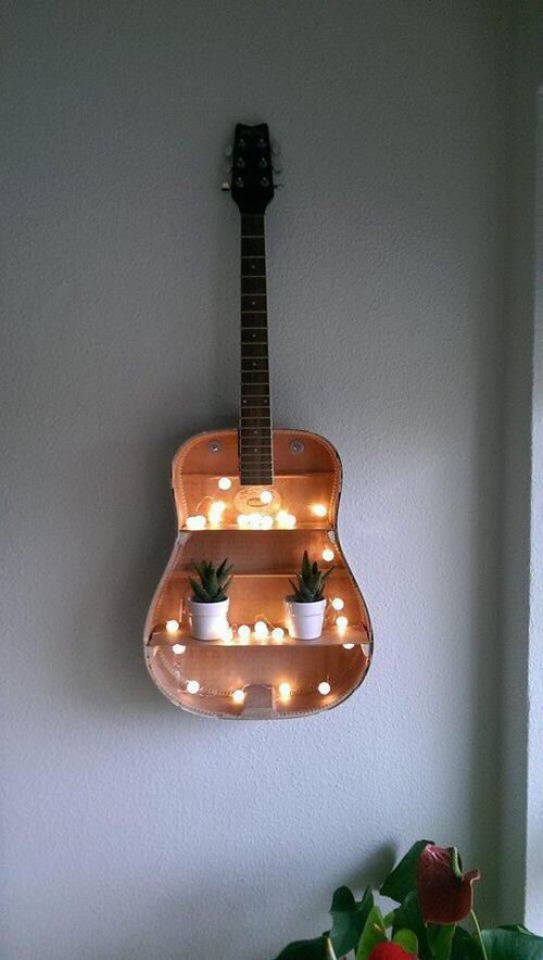 a guitar shaped shelf with lights on it