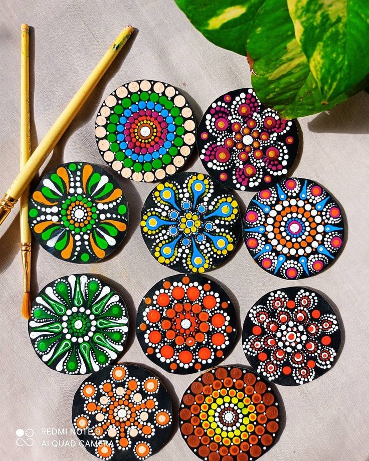 a group of painted discs sitting next to a pencil on top of a white table