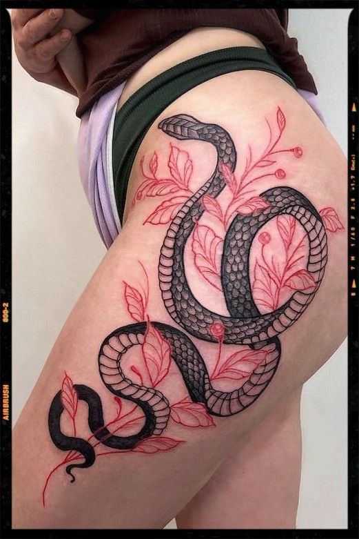 a woman's thigh with a snake tattoo on it