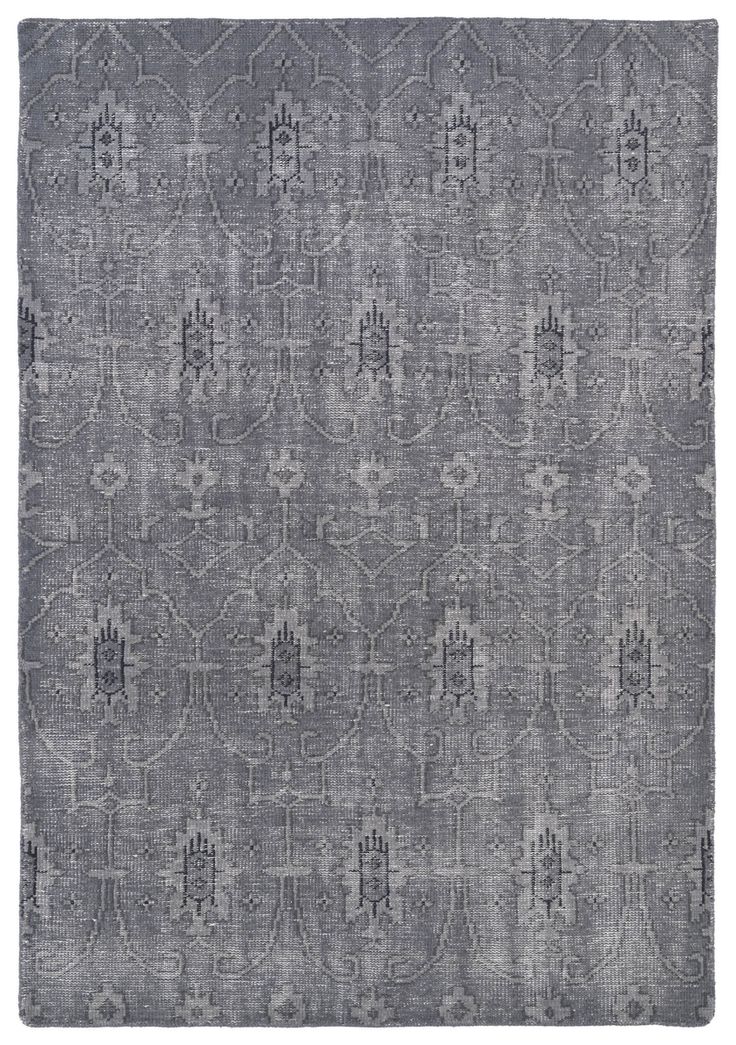 a gray rug with an intricate design on the front and back side, in grey tones