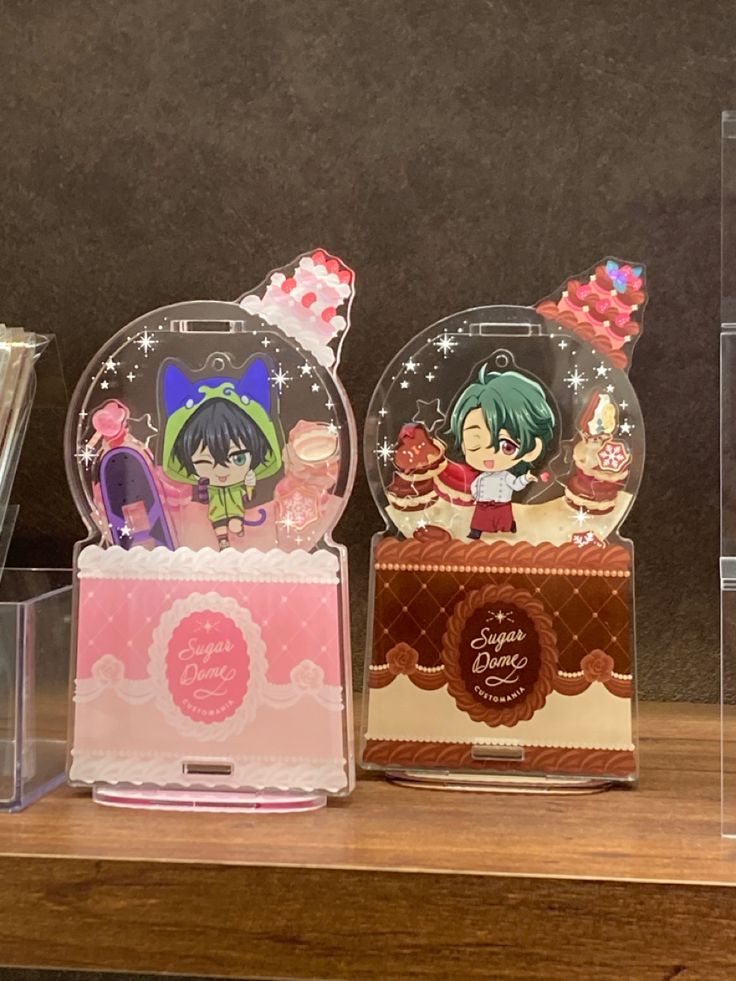 three snow globes sitting on top of a wooden table next to each other with cartoon characters in them