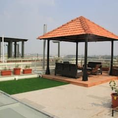 a gazebo sitting on top of a roof next to potted plants