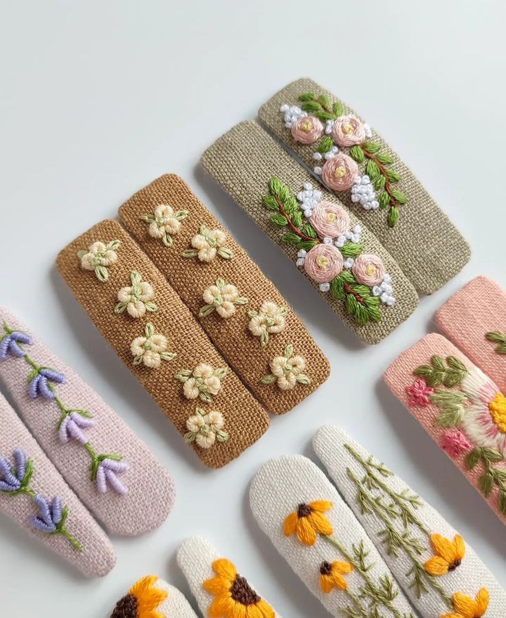 six different types of flowered knitted mitts on a white surface with flowers in them