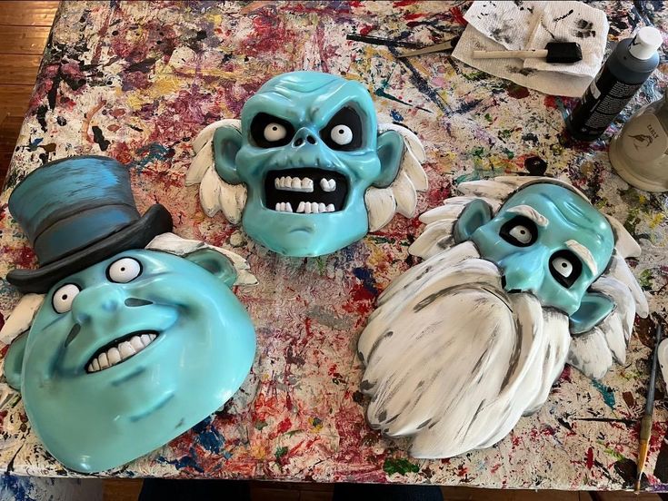 three cakes decorated to look like monsters on a table