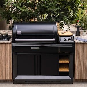 an outdoor bbq grill with the door open