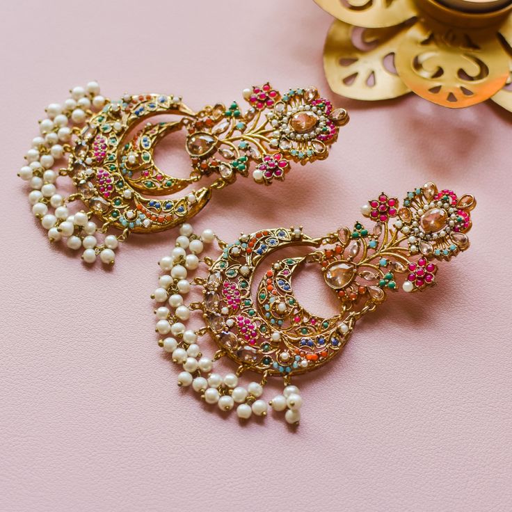 Nauratan timelessness that carry distinct style, intricacy and craftsmanship of a bygone era! A talismanic pair studded with ethereal stones and the grace of pearl moti along with the radiance of traditional and aesthetic identity. Approximate earrings length is 4". Gold-plated on high-quality brass as base metal. Made by order. Kindly allow 5-7 weeks for the delivery of this item. For custom or urgent requests, please contact support@alacouture.com. *Please Note: The multi-colored beadwork migh Diwali Sale, Bygone Era, Faux Stone, The Grace, Base Metal, Multi Colored, Bead Work, Free Gifts, Gold Plate