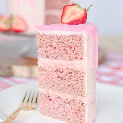 a slice of strawberry cake on a plate with a fork